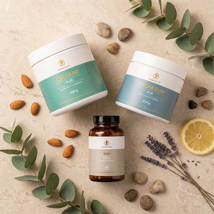 Flat-Lay-Arrangement von Supplera Calcium PUR 400g, Ionisches Magnesium PUR 250g und Bor Spurenelement 1,5 mg auf hellem Naturstein, umgeben von Eukalyptus, Mandeln, Lavendel und Zitrone – Mineralstoffe und Spurenelemente zur Erhaltung normaler Knochen und zur Unterstützung gesunder Gelenke
